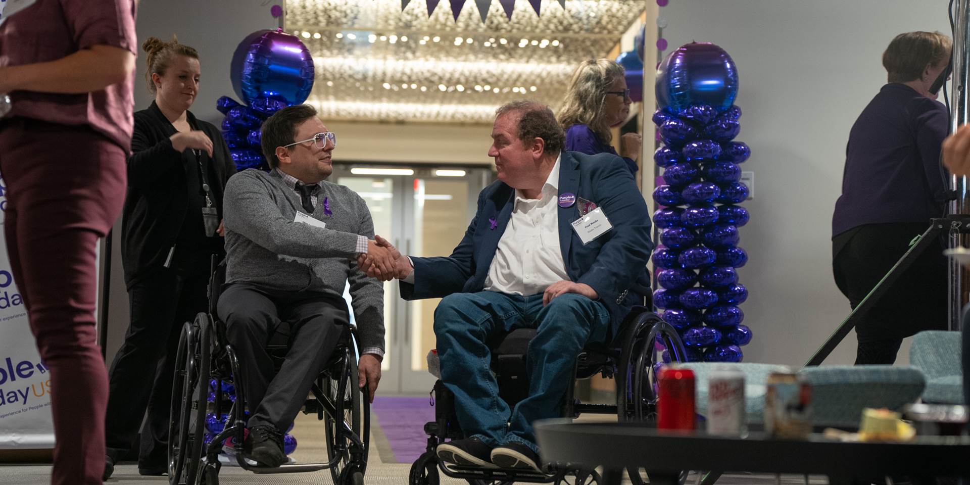 A picture of two men in wheelchairs shaking hands 